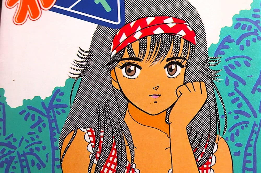 1巻表紙。小麦色に肌の焼けた鮎川まどかが、すこしだけ口角を上げながら、こちらをじっと見つめている様子です。